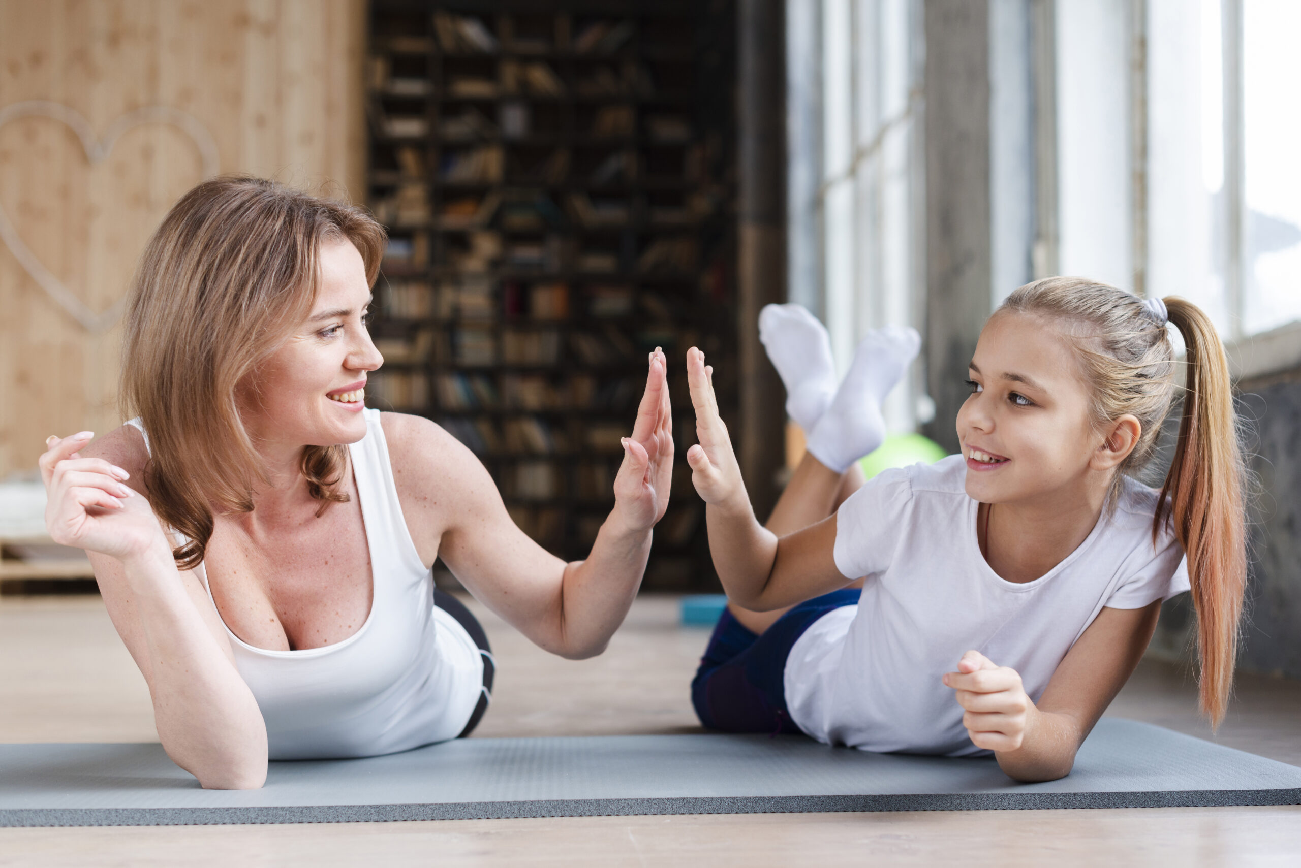 mother-daughter-high-fiving-yoga-mats