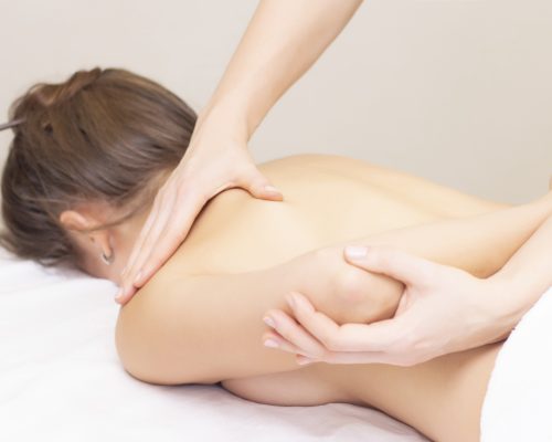 Massage and body care. Spa woman body massage with hands treatment. Stretching the back muscles. Woman having massage at the spa for beautiful girl